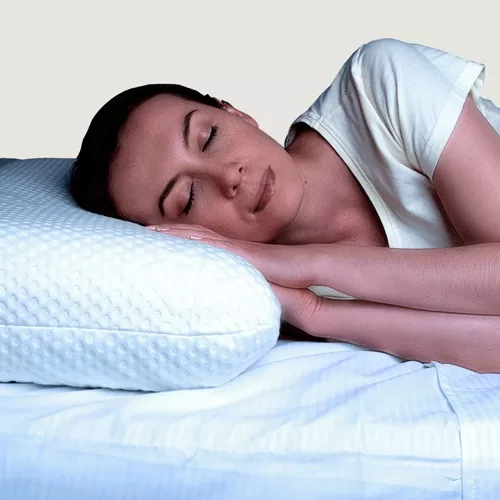 Chica durmiendo plácidamente usando una almohada Nikken que promueve descanso profundo y relajación sin estrés